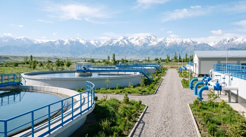 New water treatment plant with clarifier basins against snow-capped mountains